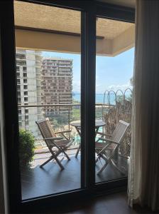 uma vista para uma varanda com uma mesa e cadeiras em Cozy apartment with a great view em Chakvi