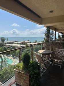 uma varanda com uma mesa e cadeiras e o oceano em Cozy apartment with a great view em Chakvi