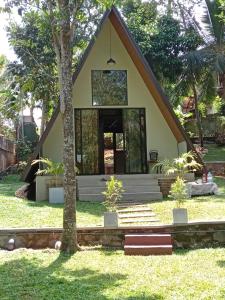 a small house with a tree in the yard at River View Cabana in Galle