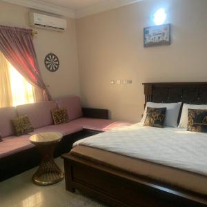 een slaapkamer met een bed en een bank bij HP Pavilion in Abuja