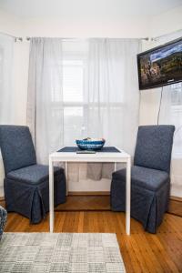 a white table with two chairs and a bowl on it at Renovated, Sunny, Spacious Studio In Boston in Boston