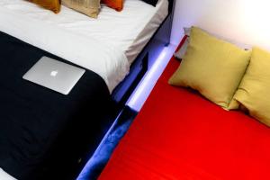 - un lit avec un ordinateur portable installé au-dessus dans l'établissement Flexi-Living Premium Condo in Kasara, à Manille