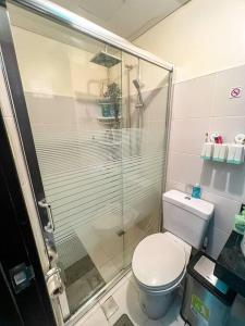 een badkamer met een toilet en een glazen douche bij Flexi-Living Premium Condo in Kasara in Manilla