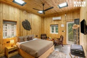 a bedroom with a bed in a room with wooden walls at StayVista at The Black Bean Cottage with Breakfast Included & Pet Friendly in Wayanad