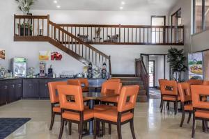 a dining room with a table and orange chairs at Quality Inn and Suites in Stuttgart