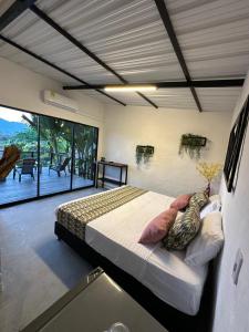 a bedroom with a large bed and a large window at Flor del Monte in Sopetran