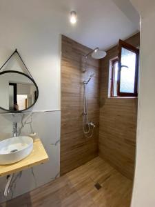 a bathroom with a shower with a sink and a mirror at Vavla House in Berat