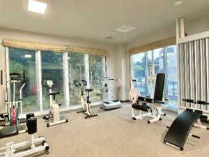 een fitnessruimte met diverse fitnessapparatuur in een kamer met ramen bij HOTEL HOLISTIC RESORT - Vacation STAY 34549v in Taiji