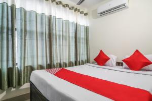 a bedroom with two beds with red pillows at OYO Flagship Hotel Lokenath in Jamshedpur