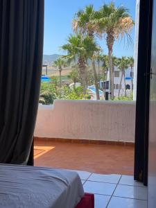 sypialnia z widokiem na balkon z palmami w obiekcie Bahia Smir et Al Amin Plage Front mer w mieście Al-Funajdik