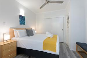 ein Schlafzimmer mit einem weißen Bett und einem Nachttisch in der Unterkunft 1 Bedroom @ Palm Villas #3 in Port Douglas