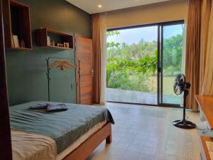 a bedroom with a bed and a large window at COMFY Riverside Mekong homestay in Ấp Phú Hòa (3)