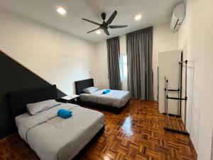 a hotel room with two beds and a ceiling fan at MR homestay depo link in Kuching