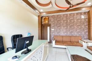Camera con scrivania, computer e divano. di Super OYO Jagmohan Hotel a Jodhpur