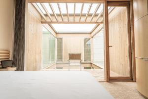 a room with a bed and a glass door at Shonai Hotel Suiden Terrasse in Tsuruoka