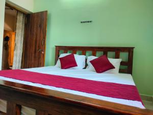 un letto con cuscini rossi e bianchi di AthmA ArunA - Homestay Tiruvannamalai a Tiruvannāmalai
