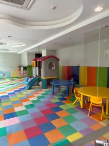 ein Kinderspielzimmer mit bunten Böden und Tischen in der Unterkunft Apartemen Puri Mansion Cozy, Lokasi Strategis in Jakarta