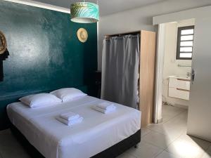 sypialnia z białym łóżkiem i zieloną ścianą w obiekcie Les roches noires résidence w mieście Saint-Gilles les Bains