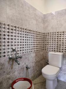 AthmA ArunA - Homestay Tiruvannamalai في تيروفانمالي: حمام به مرحاض أبيض ومغسلة