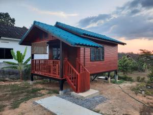a small red house with a blue roof at Lucky Bungalow in Khao Lak