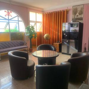 een woonkamer met een tafel en stoelen bij HP Pavilion in Abuja