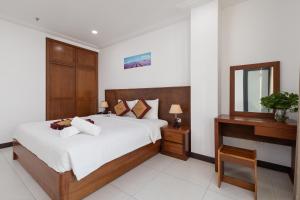 a bedroom with a large bed and a mirror at Star Hotel and Spa Danang in Danang