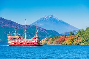 un navire de croisière sur l'eau avec une montagne en arrière-plan dans l'établissement NEW OPEN『天然温泉』芦ノ湖畔の完全貸切別荘, à Hakone