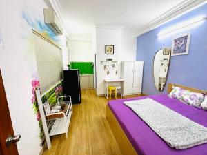 ein Schlafzimmer mit einem lila Bett und einem Spiegel in der Unterkunft Le Nhim Homestay in Ho-Chi-Minh-Stadt