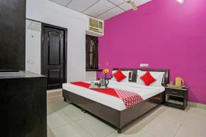 1 dormitorio con 1 cama con pared de color rosa en Flagship Hotel Mahi, en Pānīpat
