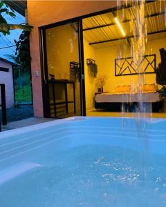 a swimming pool with a fountain in front of a house at Flor del Monte in Sopetran