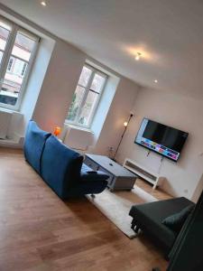 a living room with a blue couch and a flat screen tv at Le Cocoon Lumineux et Spacieux-Wi-Fi-TV-25min STRG in Wasselonne