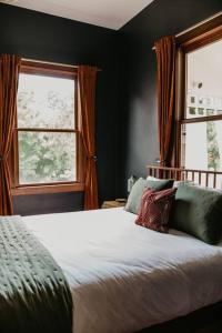 um quarto com uma cama grande e 2 janelas em 1 bedroom Modern Victorian in heart of downtown em Nevada City