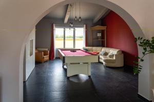 Habitación con mesa de ping pong y sofá en Gite L olivier, en Baho