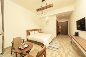 1 dormitorio con 1 cama, mesa y sillas en Romeo & Juliet Dalat Resort en Dalat