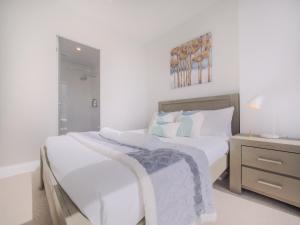 een witte slaapkamer met 2 bedden en een nachtkastje bij Delightful 1br1ba Carlton With Great Location in Melbourne