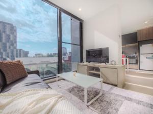 een woonkamer met een bank en een groot raam bij Delightful 1br1ba Carlton With Great Location in Melbourne