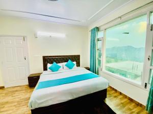 a bedroom with a large bed with a large window at Royal Green Valley View Mashobra in Shimla