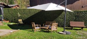 a table and two chairs under an umbrella at Appartement meublé classé 3 étoiles de 72 m2, 2 chambres in Morzine