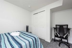 a bedroom with a bed and a black chair at Tee's Haven in Calgary
