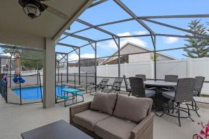 un patio con sofá, mesa y sillas en Wonderful Weston Hills Villa SE Facing Pool, en Orlando