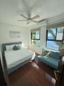 um quarto com uma cama e uma ventoinha de tecto em ZenStay Retreats Private Luxury Beach House Rental em Pandan