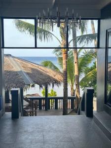 a view of a patio with a table and palm trees at ZenStay Retreats Private Luxury Beach House Rental in Pandan