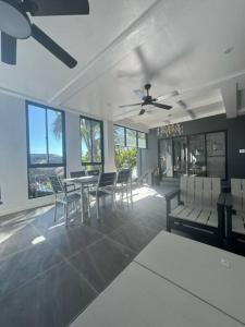 a dining room with a table and chairs and windows at ZenStay Retreats Private Luxury Beach House Rental in Pandan