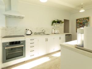 a kitchen with white cabinets and a stainless steel oven at The Lookout in Karitane