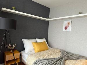 Exotic Spacious Stylish Apartment Retreat في Ris-Orangis: غرفة نوم بسرير ومخدة صفراء