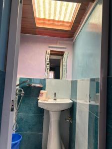 een badkamer met een wastafel en een spiegel bij Sovan Homestay in Sonāda