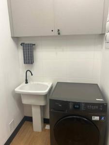 a small bathroom with a sink and a dishwasher at EXCELENTE Studio V915 Vila Olímpia in Sao Paulo