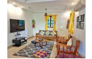 a living room with a couch and a table at Ronne's Casa De Piscina Privada 3BHK VILLA in Verla