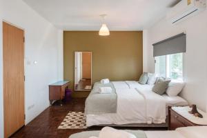 a bedroom with a large bed and a window at Thonglor House by Panisa in Klong Toi