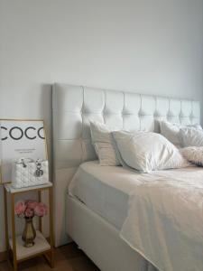 een wit bed met een wit hoofdeinde en een bijzettafel bij Luxury apartment with stunning view - Guillemins in Brussel